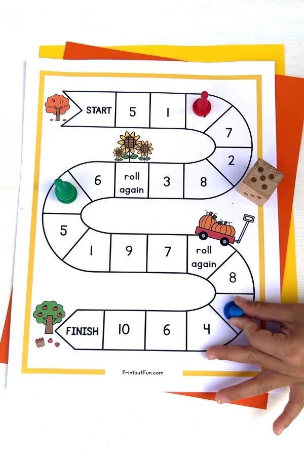 A child's hand moving a game pawn on the unicorn number recognition board game.