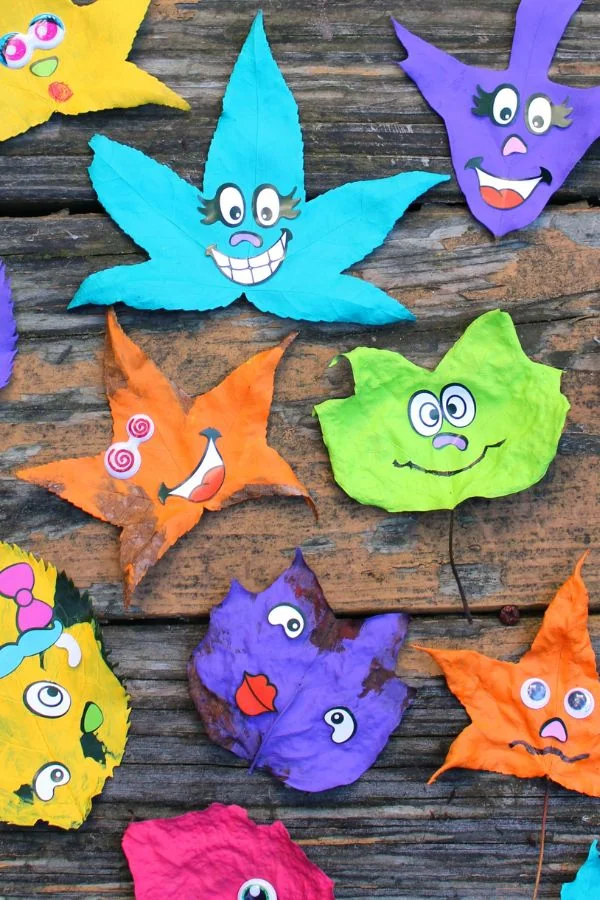 A collection of silly painted leaf monsters spread out of a table.